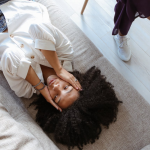 A woman lying on a couch during a therapy session, expressing emotions.